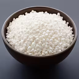 a bowl filled with sugar next to a spoon