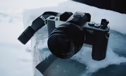 a camera sitting in the snow near the snow