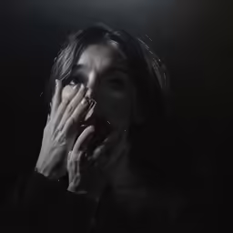 the young woman is covering her face with both hands