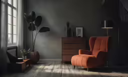 an orange chair sits in front of a tall window
