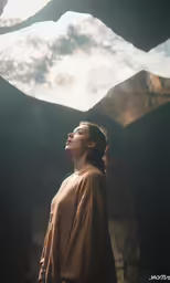 a woman with long hair standing in front of a mountain