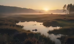the sun is rising over some hills next to a river