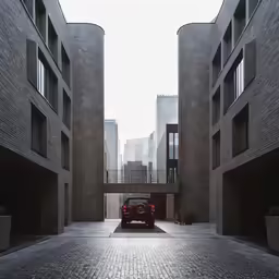 the red car is driving under a bridge in the city