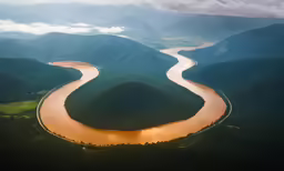 the river curves quickly across the valley from a mountain