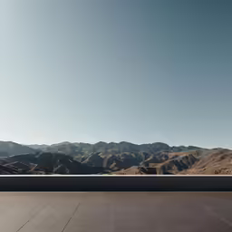 a concrete patio and mountain range in the distance