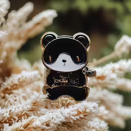 a teddy bear brooche pin sitting on top of some fake flowers