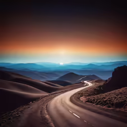a winding road leading into a sunset sky