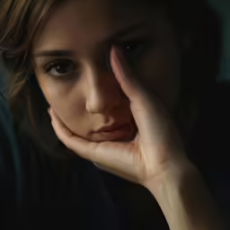 a close up of a person leaning on her hand
