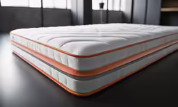 a close up of an orange and white mattress on a table