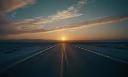 a road in the desert with sun setting in background