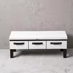 a white drawer unit with two drawers and black handles