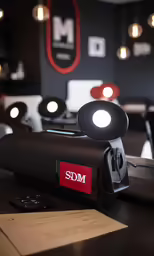 a cell phone is next to some lights and paperwork