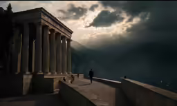 a person walking towards some tall pillars