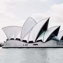 a very tall modern structure sitting in the middle of water