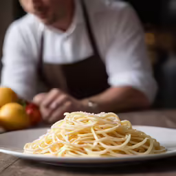 a man is preparing some noodles on the table