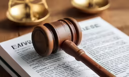 the wooden gavel has been placed atop an open law book