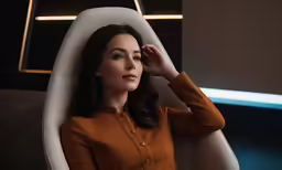a woman in a brown blouse is sitting down