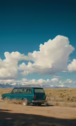 a van parked on a dirt road next to a field