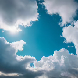the sky filled with fluffy clouds and a bright sun