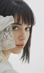 a young woman wearing a white veil and black hair