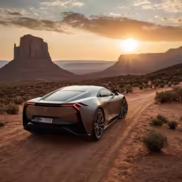 the all - electric sports car driving along a dirt road with mountains and desert in the background