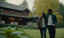 a young couple is walking in the yard