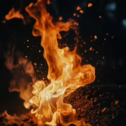 a big fire blazing and floating on top of some dirt
