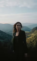 a beautiful woman posing on top of a mountain