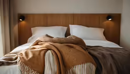 a bed with white pillows and blankets on it