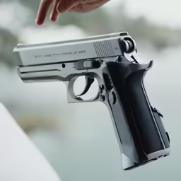 someone is holding onto a tiny gun with its sights exposed
