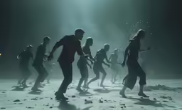 a group of people in black clothes are dancing