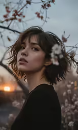 a woman stands by a blossoming tree