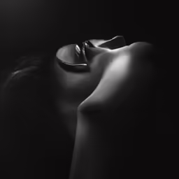 a black and white photo of a female body with rings around her neck