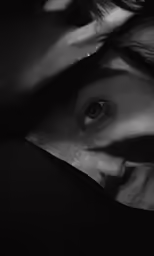 a woman with brown eyes covering her face
