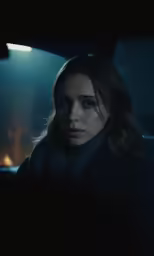 a woman sitting in a car at night
