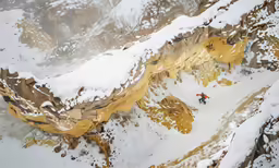 a man on snowboard up to the side of a mountain