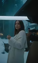 the woman in white coat stands under a beam