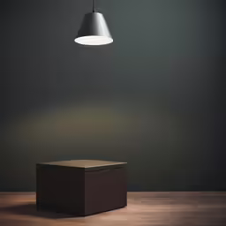 a single light is suspended above a small square box