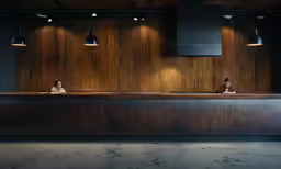a couple of people sitting at a desk next to some lights