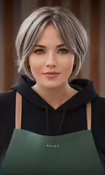 a woman in black top and dark hoodie holding a green handbag