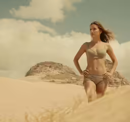 the woman is running on the beach in the sand