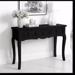 a black console table with three drawers and a vase