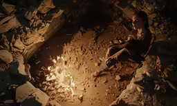 the girl is sitting at the campfire in the dark