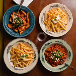 four plates on a table with various food on them