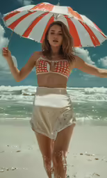 a woman in bikini and white skirt with umbrella on beach