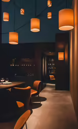 a room that has chairs and lamps hanging from the ceiling