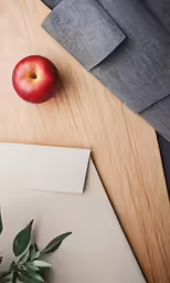 an apple on top of a piece of paper near a piece of paper