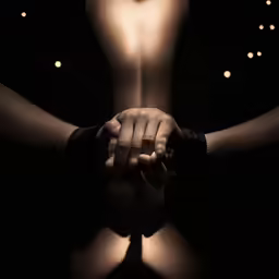 the bottom half of a mans torso holding his hand