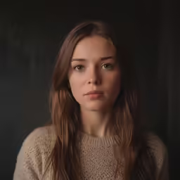 a young woman poses for a photo wearing a brown sweater