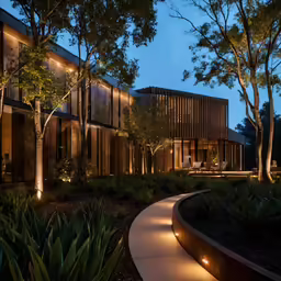 a modern house lit up with landscape lighting